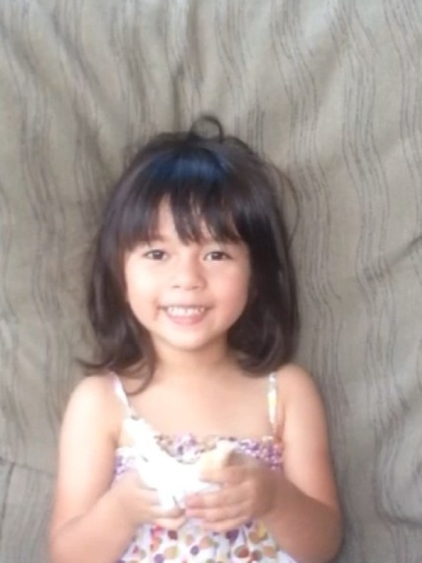 A closeup Alba smiling happily while sitting out on the lanai